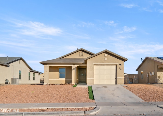 single story home with central AC unit and a garage