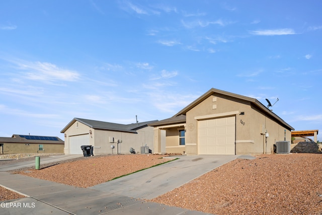 view of front of house with a garage and central air condition unit