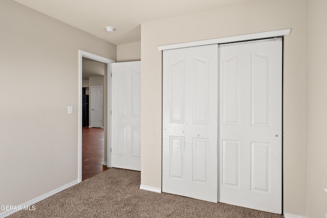 unfurnished bedroom with a closet and carpet flooring