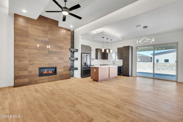 kitchen featuring hanging light fixtures, a kitchen island, stainless steel refrigerator with ice dispenser, and light hardwood / wood-style floors