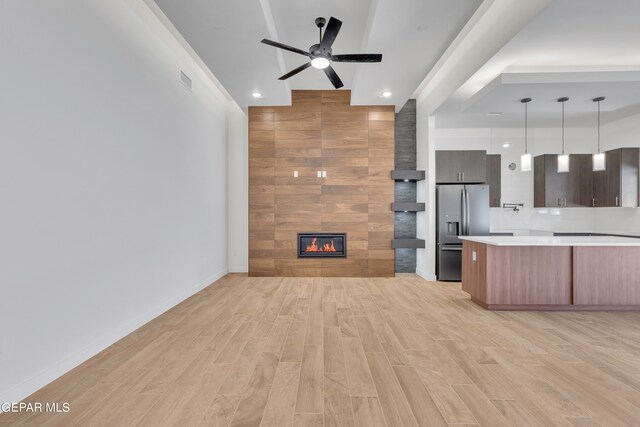 unfurnished living room featuring light hardwood / wood-style flooring, a fireplace, and ceiling fan