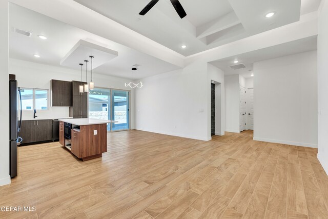 kitchen featuring a healthy amount of sunlight, a center island, pendant lighting, and light wood-type flooring