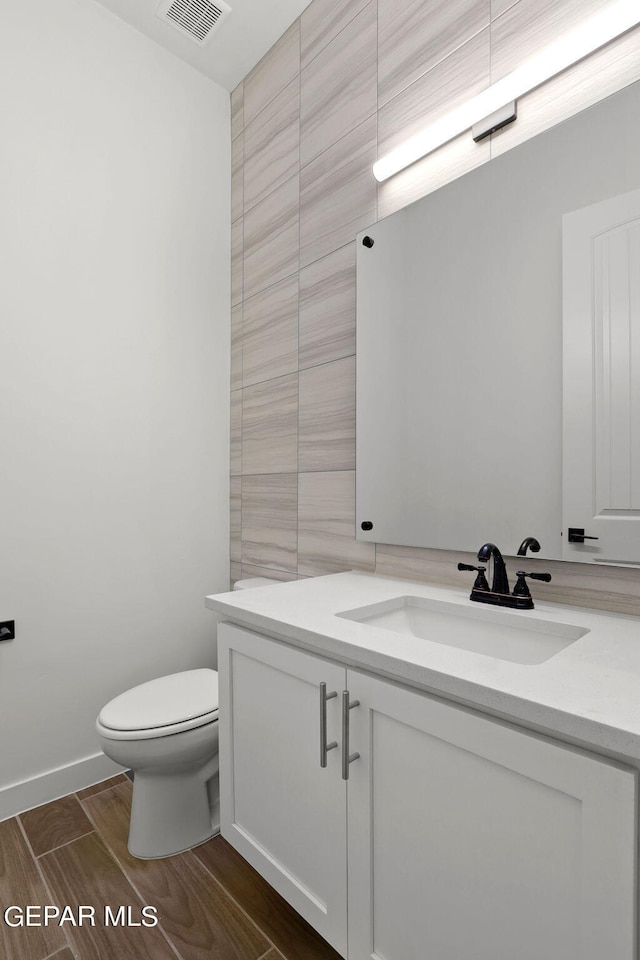 bathroom with vanity, hardwood / wood-style flooring, and toilet