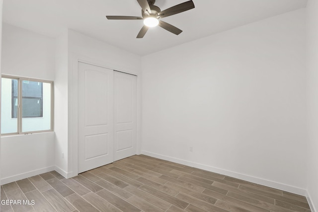 unfurnished bedroom featuring a closet, light hardwood / wood-style floors, and ceiling fan