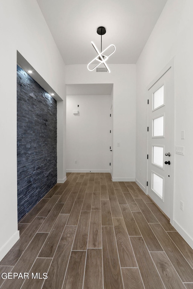 foyer with an inviting chandelier and dark hardwood / wood-style floors