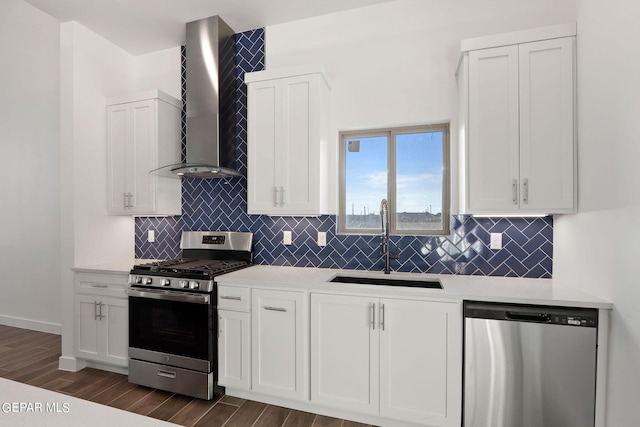 kitchen featuring white cabinets, dark hardwood / wood-style flooring, sink, wall chimney exhaust hood, and stainless steel appliances