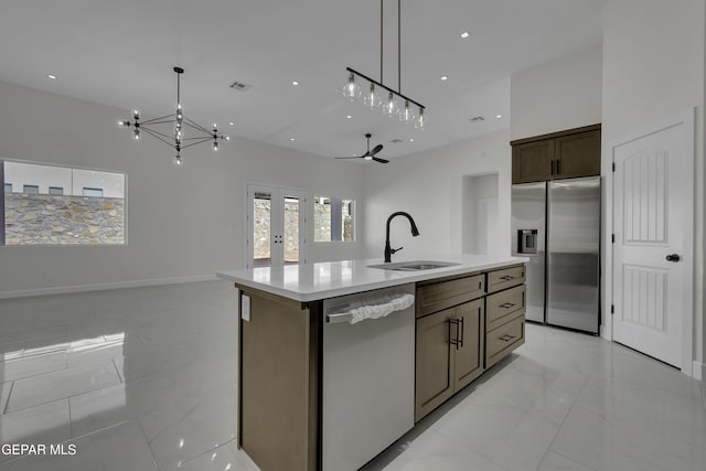 kitchen with hanging light fixtures, an island with sink, appliances with stainless steel finishes, and sink