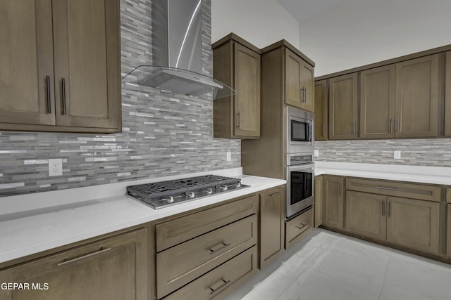 kitchen featuring backsplash, appliances with stainless steel finishes, and wall chimney exhaust hood