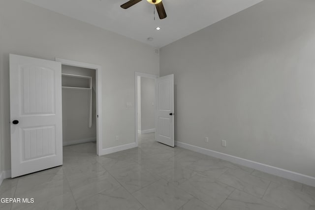 unfurnished bedroom with a closet, ceiling fan, and a spacious closet