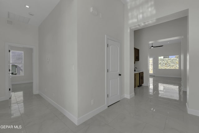 corridor featuring a high ceiling and sink