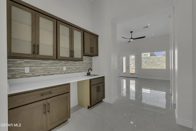 kitchen featuring sink, ceiling fan, french doors, and decorative backsplash