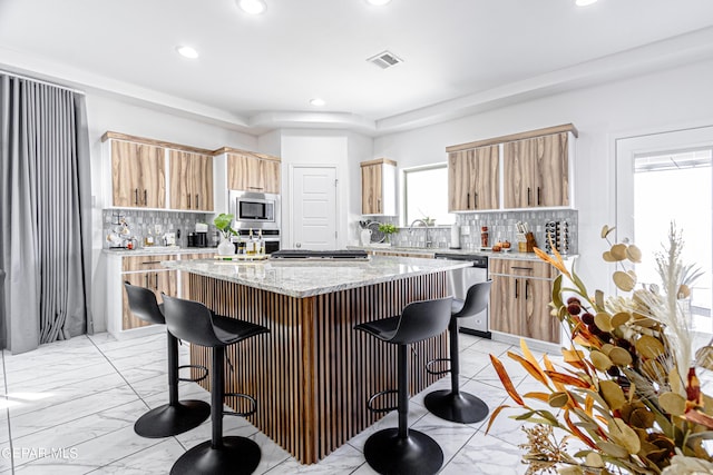 341 Sleepy Run St, El Paso, TX 79928 - kitchen featuring appliances with stainless steel finishes, a kitchen bar, decorative backsplash, a kitchen island, and recessed lighting