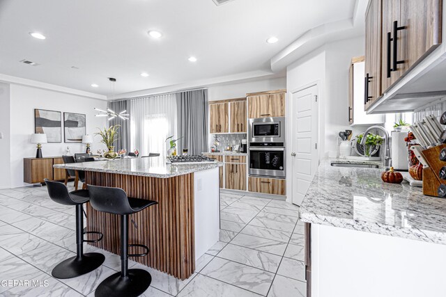 341 Sleepy Run St, El Paso, TX 79928 - kitchen featuring stainless steel appliances, a sink, light marble finish floors, a breakfast bar area, and a center island with sink