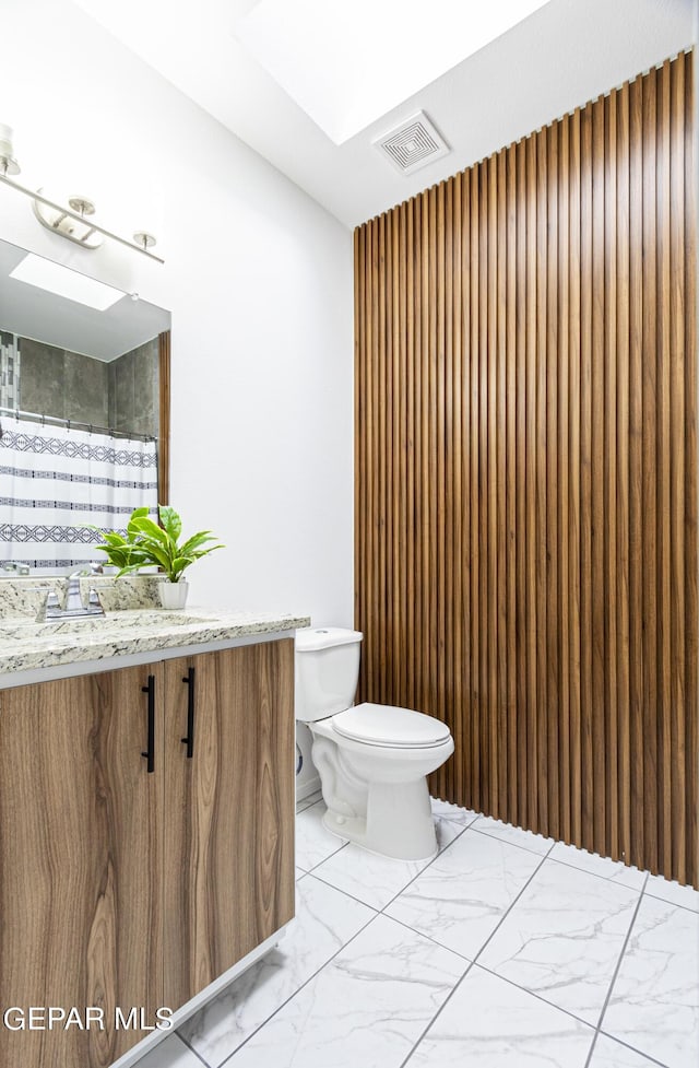 341 Sleepy Run St, El Paso, TX 79928 - full bath with marble finish floors, toilet, vanity, curtained shower, and a skylight