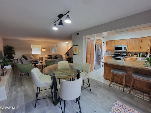 dining area featuring sink and light wood-type flooring