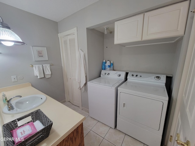 laundry room featuring light tile patterned floors, washing machine and dryer, and sink