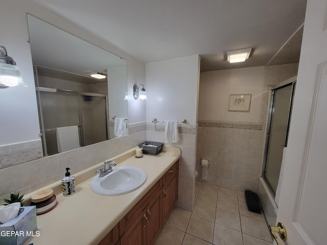 bathroom with walk in shower, tile walls, toilet, vanity, and tile patterned floors