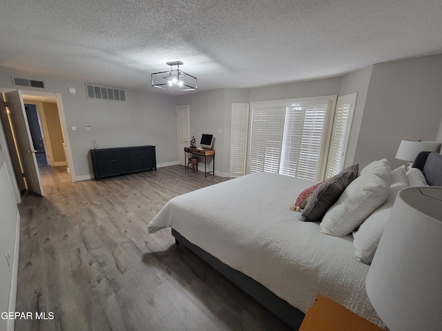 bedroom featuring a textured ceiling and wood-type flooring