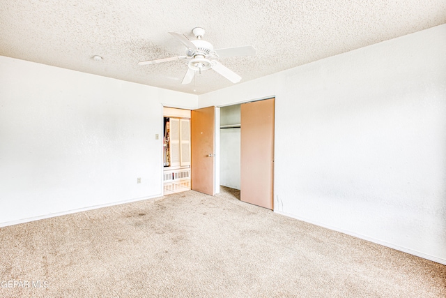 unfurnished bedroom with a textured ceiling, carpet flooring, and ceiling fan