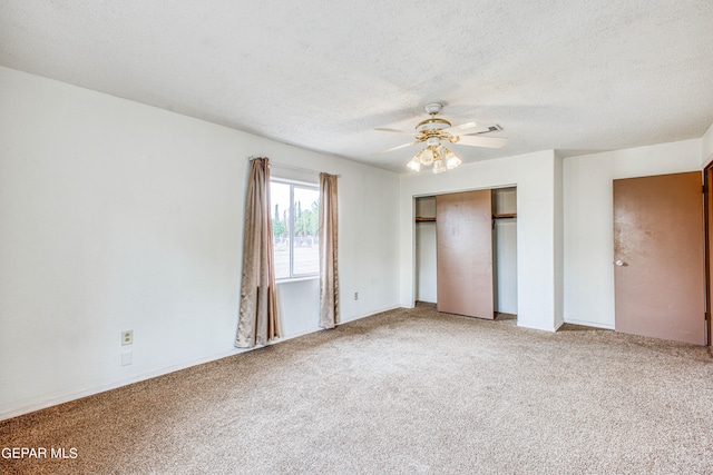 unfurnished bedroom with a textured ceiling, carpet floors, a closet, and ceiling fan