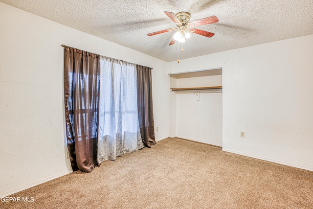 unfurnished bedroom featuring a textured ceiling, carpet flooring, a closet, and ceiling fan