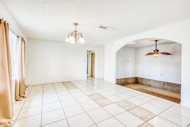 tiled empty room with a textured ceiling and ceiling fan with notable chandelier