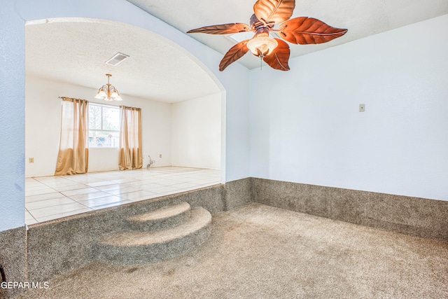 carpeted spare room with ceiling fan and a textured ceiling