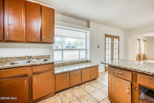 kitchen with sink, french doors, and light tile patterned flooring