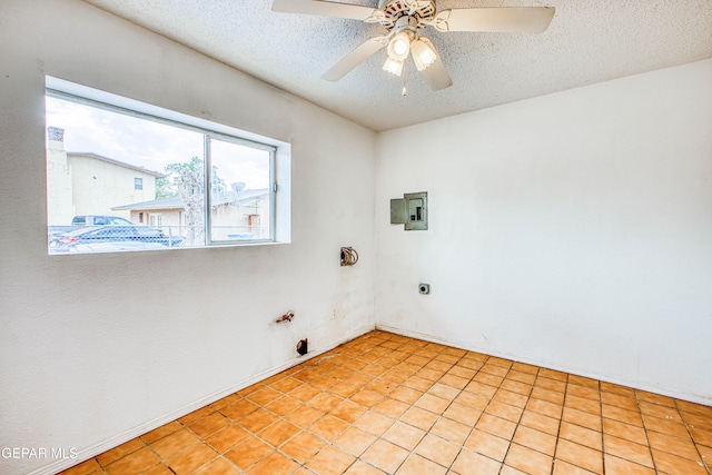 clothes washing area featuring ceiling fan, light tile patterned floors, a textured ceiling, hookup for a gas dryer, and hookup for an electric dryer