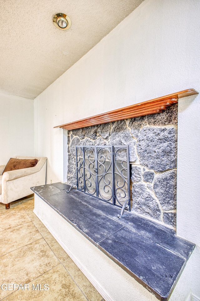 interior details featuring tile patterned floors, a textured ceiling, and a fireplace