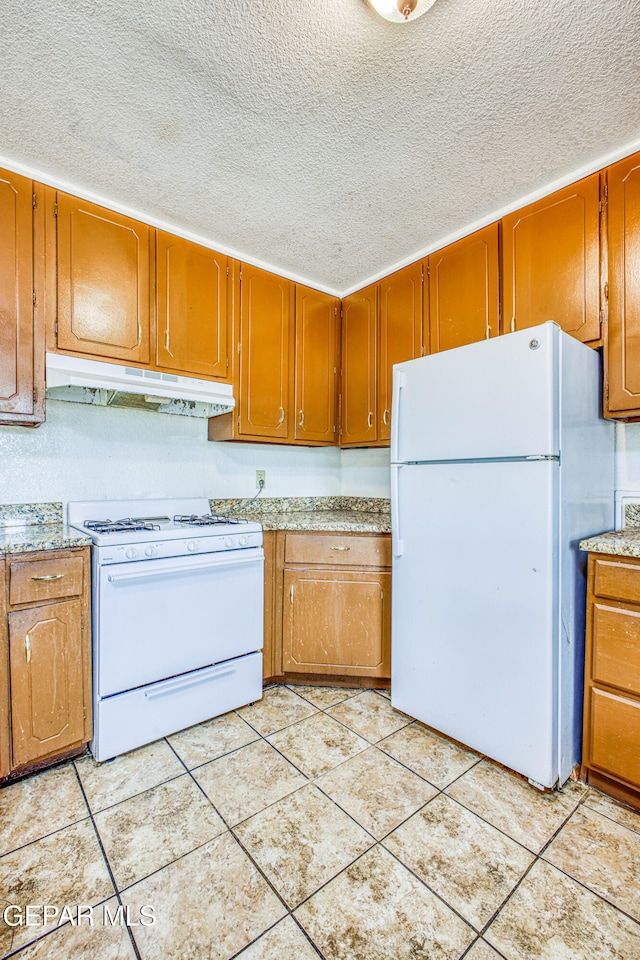 kitchen with white appliances, a textured ceiling, and light tile patterned floors