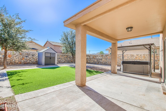 view of patio / terrace featuring a hot tub and a storage shed