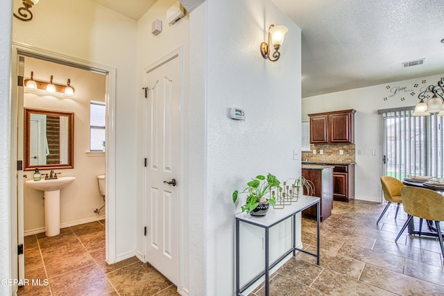 hallway with sink and a textured ceiling