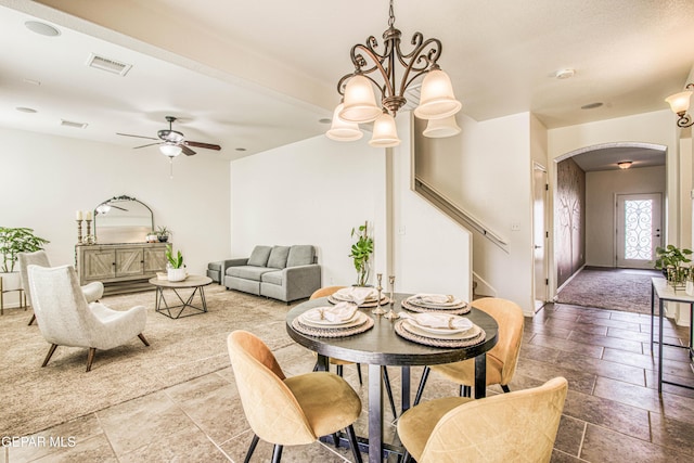 dining space featuring ceiling fan with notable chandelier