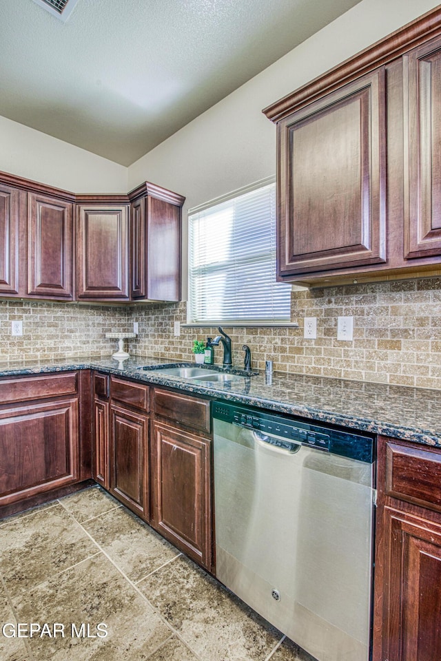 kitchen featuring backsplash, dark stone countertops, dishwasher, and sink