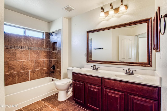 full bathroom featuring tile patterned flooring, vanity, toilet, and tiled shower / bath