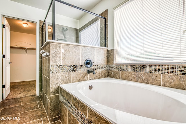 bathroom featuring shower with separate bathtub