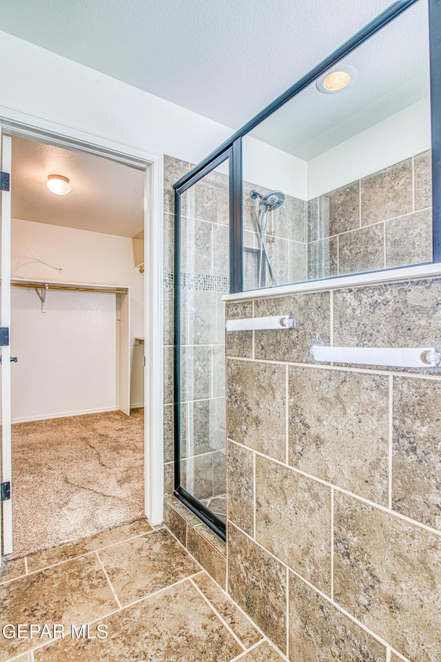 bathroom with a textured ceiling and walk in shower