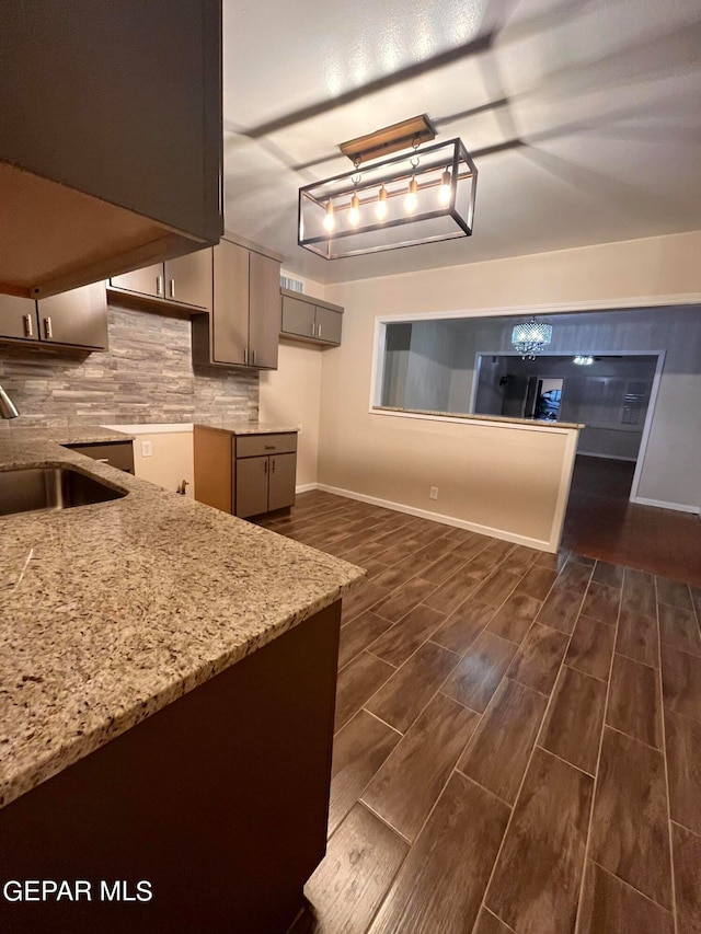 kitchen with sink, decorative backsplash, and light stone countertops