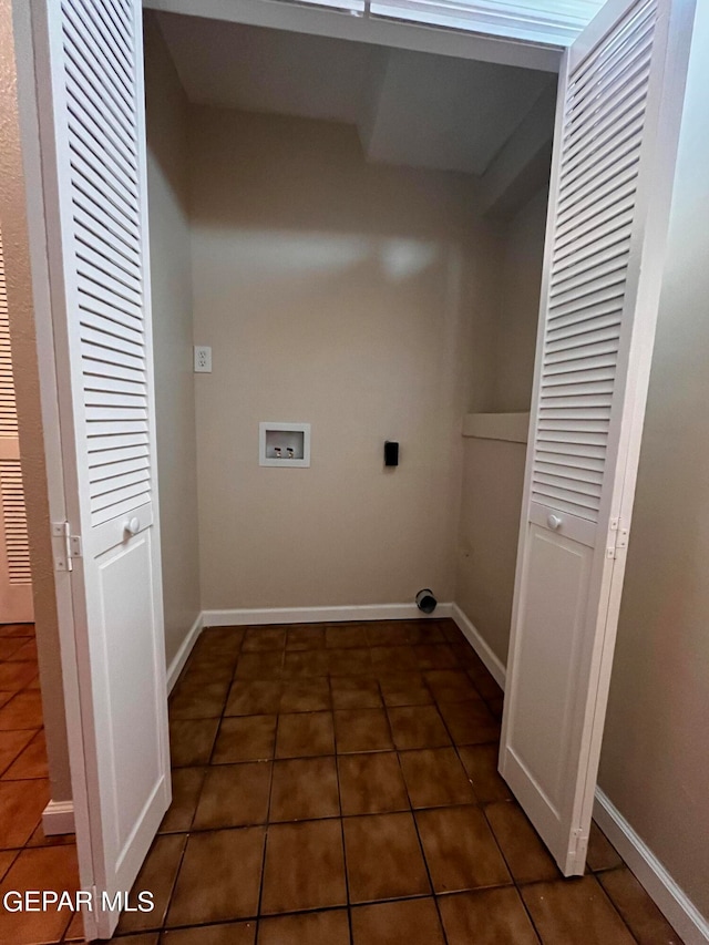 washroom with hookup for an electric dryer, hookup for a washing machine, and dark tile patterned floors