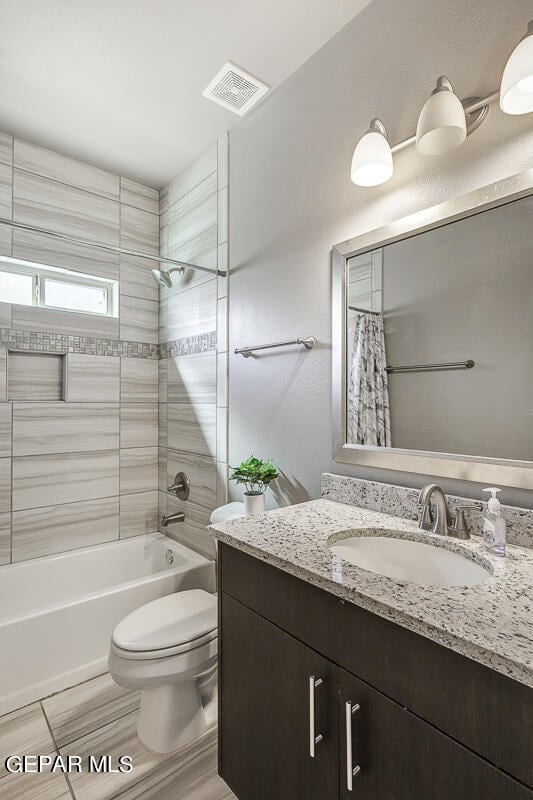 full bathroom with vanity, shower / bath combination with curtain, and toilet