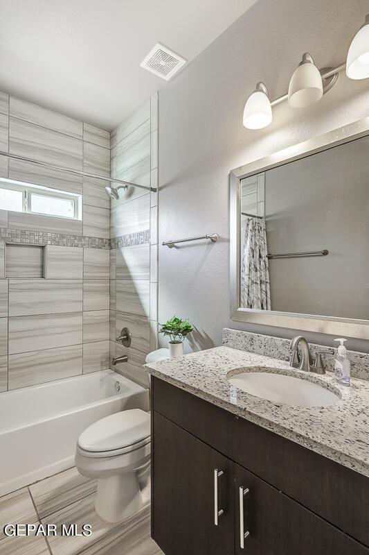 14805 Sam Garcia Ave, El Paso, TX 79938 - bathroom with toilet, shower / bath combo with shower curtain, and vanity