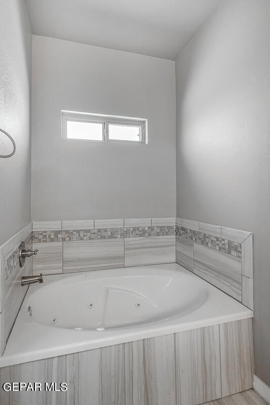 bathroom featuring a relaxing tiled tub