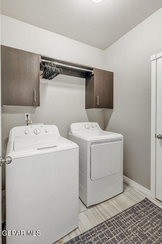 14805 Sam Garcia Ave, El Paso, TX 79938 - laundry room featuring cabinet space and washer and dryer