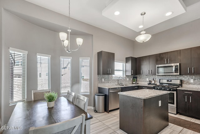 kitchen featuring stainless steel appliances, dark brown cabinetry, a center island, and pendant lighting