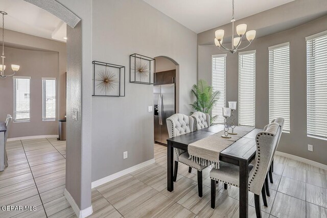 14805 Sam Garcia Ave, El Paso, TX 79938 - dining room featuring a chandelier, arched walkways, baseboards, and light tile patterned flooring