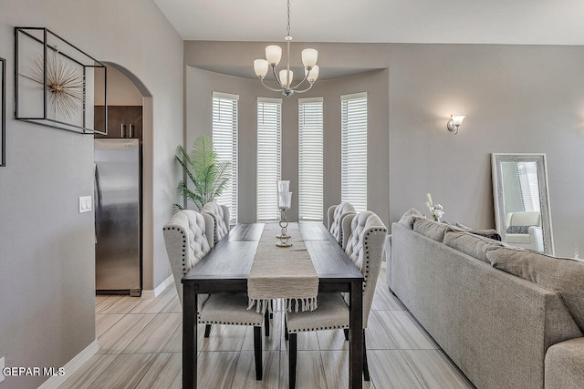 tiled dining room featuring an inviting chandelier