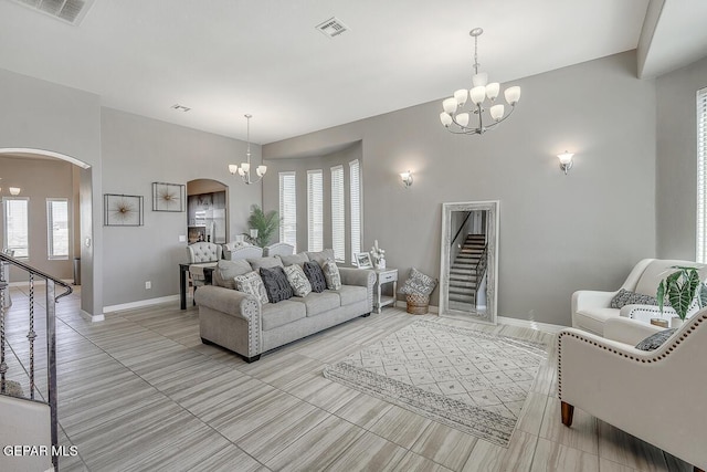 14805 Sam Garcia Ave, El Paso, TX 79938 - living room featuring arched walkways, a chandelier, baseboards, and stairway