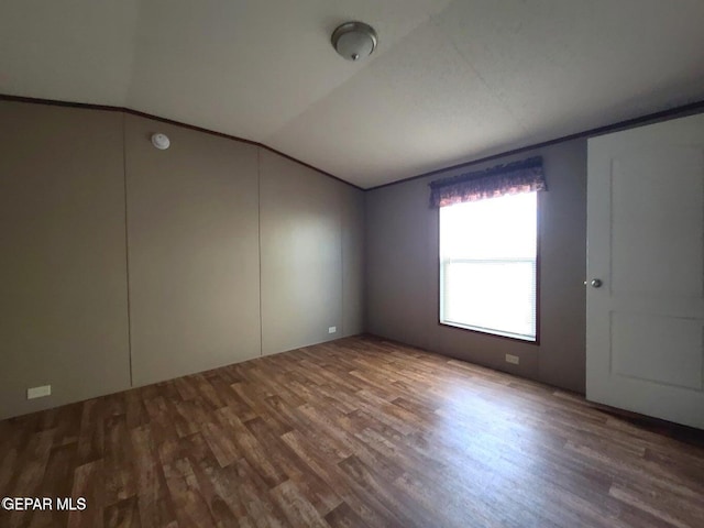 empty room featuring hardwood / wood-style floors and vaulted ceiling