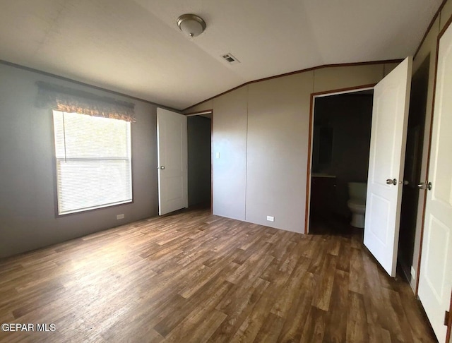 unfurnished bedroom featuring dark wood-type flooring and vaulted ceiling